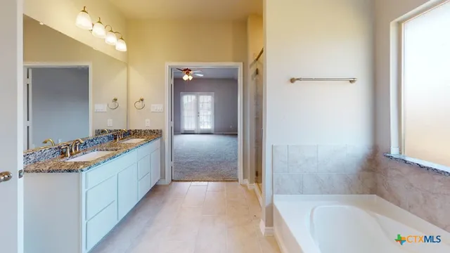 a bathroom with a tub sink and mirror