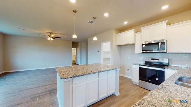 a kitchen with kitchen island a sink stainless steel appliances and cabinets