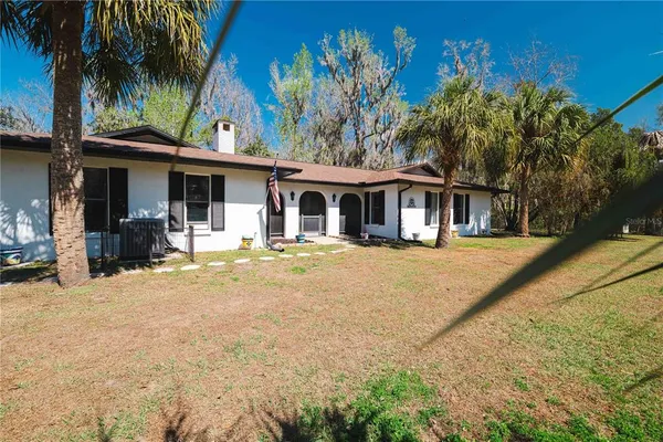 a front view of a house with a yard and tree