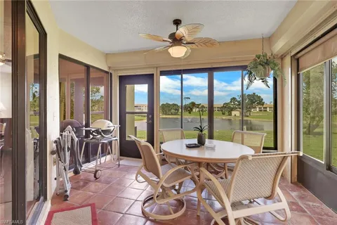 a dining room with furniture large windows and a chandelier