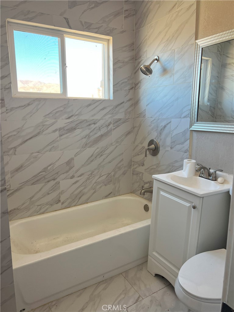 a bathroom with a sink and bathtub with toilet