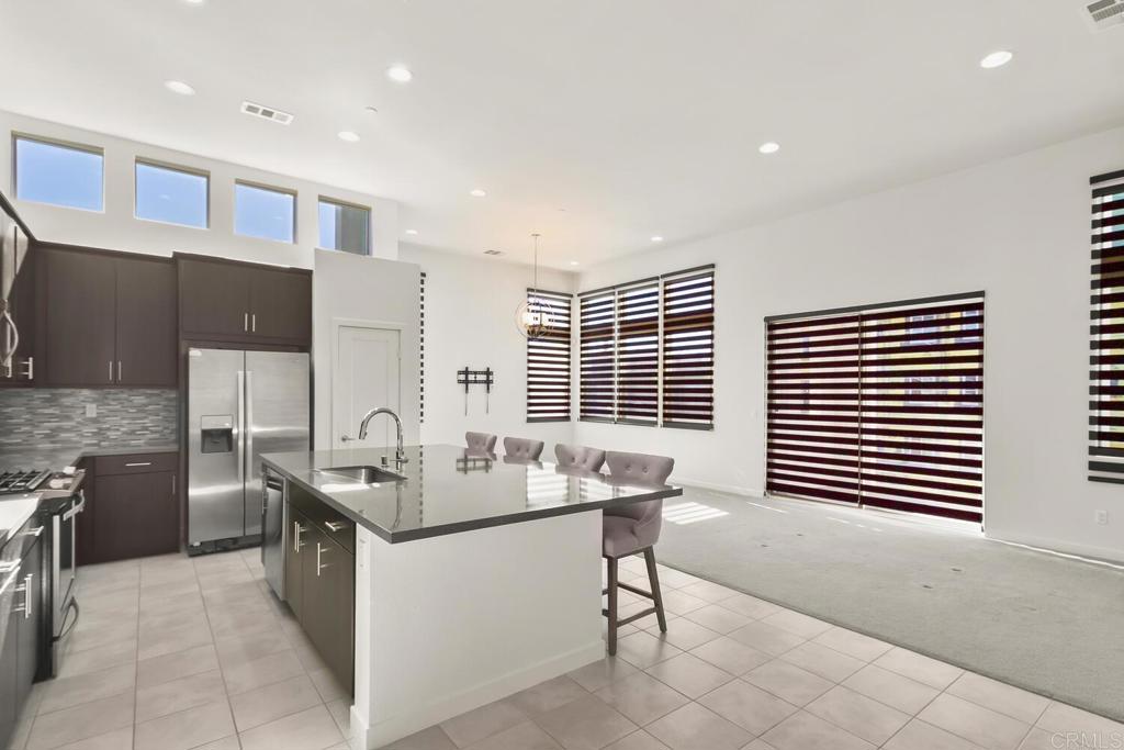 2012 Foxtrot Loop, Unit 3 Chula Vista, CA 91915 - Photo 1 of 34 a dining hall with stainless steel appliances kitchen island granite countertop a table and chairs in it