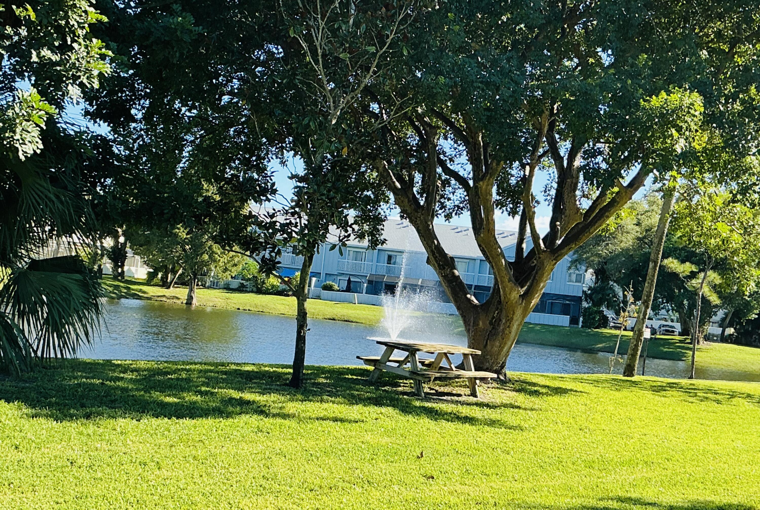 6262 Riverwalk Lane, Unit 3 Jupiter, FL 33458 - Photo 19 of 28 a view of a swimming pool with an outdoor seating and a yard