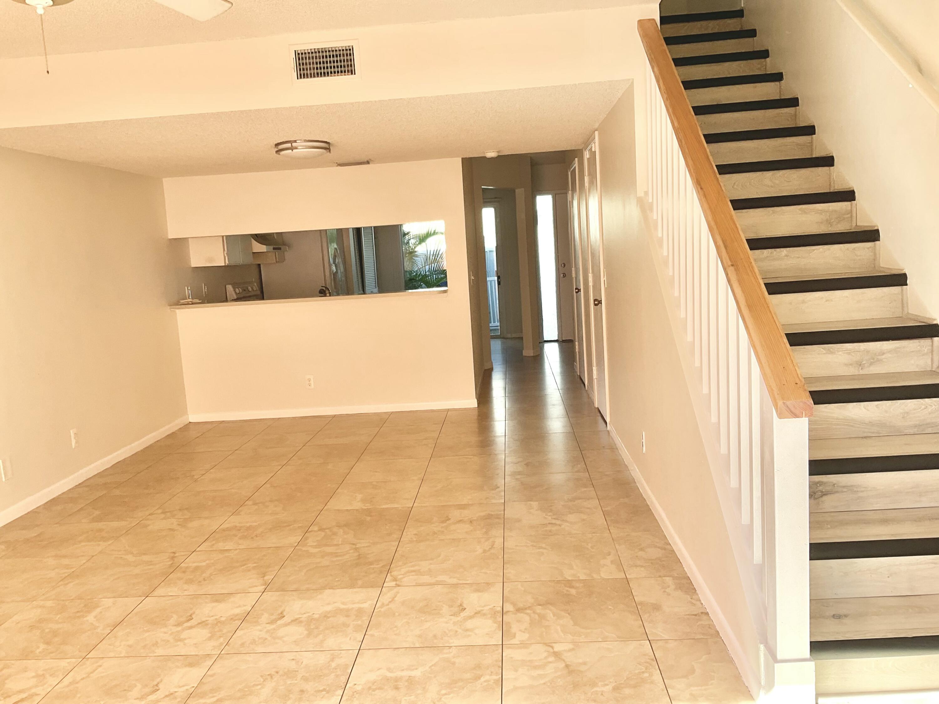 6262 Riverwalk Lane, Unit 3 Jupiter, FL 33458 - Photo 3 of 28 a view of a hallway with wooden floor and staircase