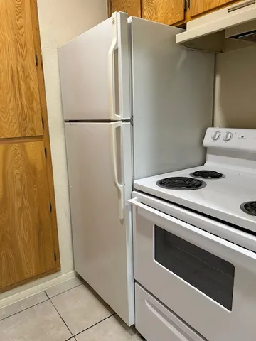 a white refrigerator freezer and a stove sitting inside of a kitchen