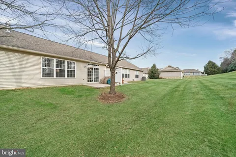 a big white house with a yard and large trees