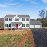 a front view of a house with a yard and large trees