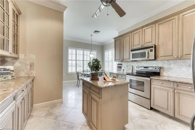 a kitchen with kitchen island granite countertop a sink stove and cabinets