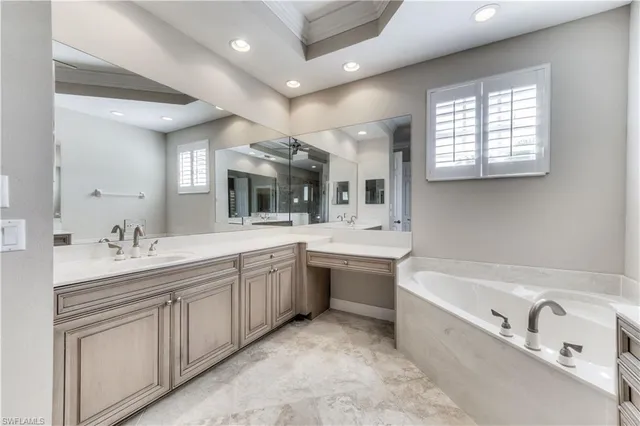 a bathroom with a granite countertop sink mirror and bathtub