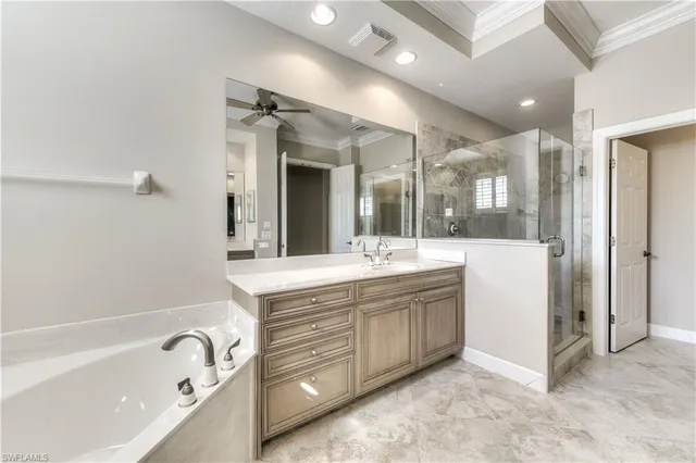 a spacious bathroom with a tub sink and mirror
