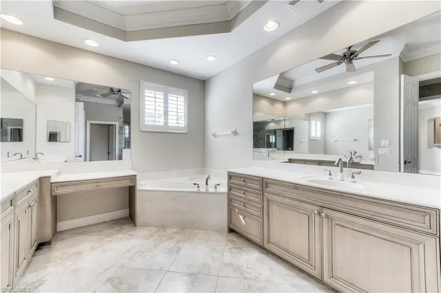 a spacious bathroom with a granite countertop sink mirror and bathtub