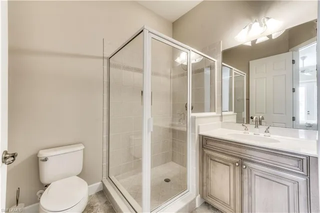 a bathroom with a sink vanity granite toilet and shower