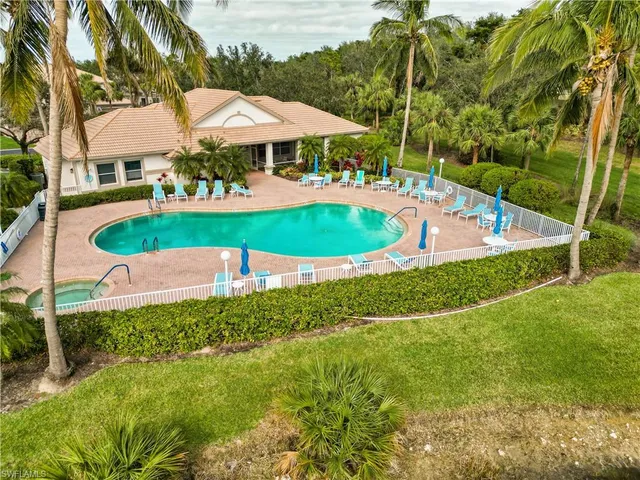 a view of a swimming pool with lawn chairs under an umbrella