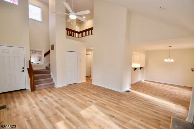 a view of a room with wooden floor and a ceiling fan