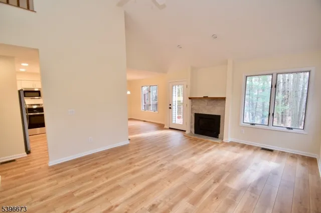 a view of a livingroom with a fireplace wooden floor and window