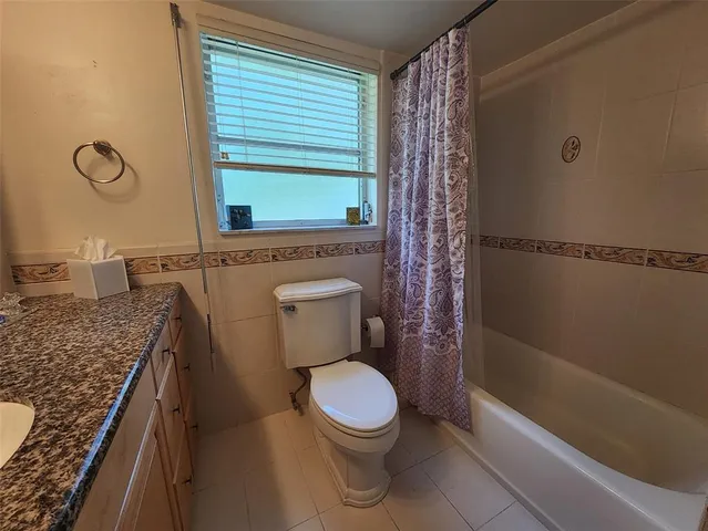 a bathroom with a granite countertop toilet a sink and bathtub