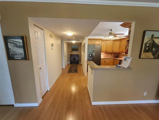 a view of a hallway with wooden floor and furniture
