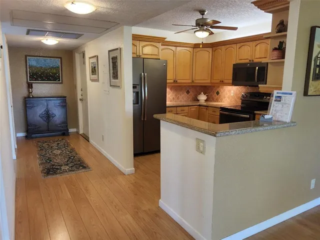 a kitchen with stainless steel appliances a refrigerator a stove a microwave and cabinets