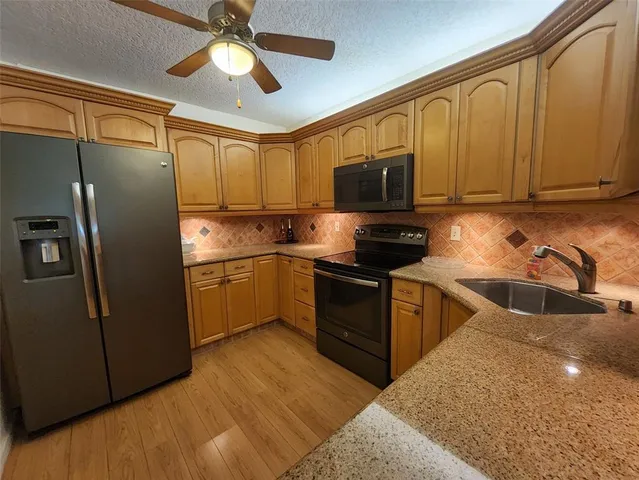 a kitchen with a refrigerator sink and cabinets