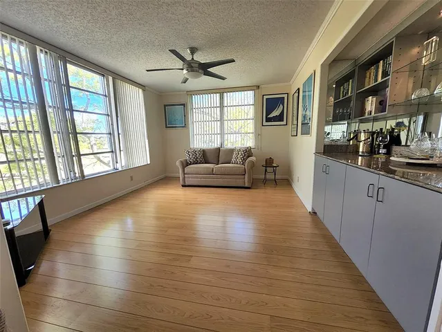 a view of a living room with furniture and large windows