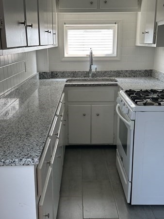 280 Ridge Street Fall River, MA 02721 - Photo 2 of 13 a kitchen with granite countertop a sink stove and cabinets