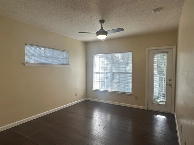 an empty room with wooden floor and windows