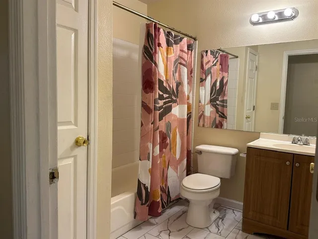a bathroom with a granite countertop toilet and a shower