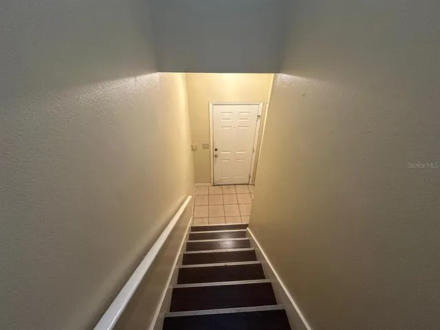 a view of a hallway with wooden floor and white walls