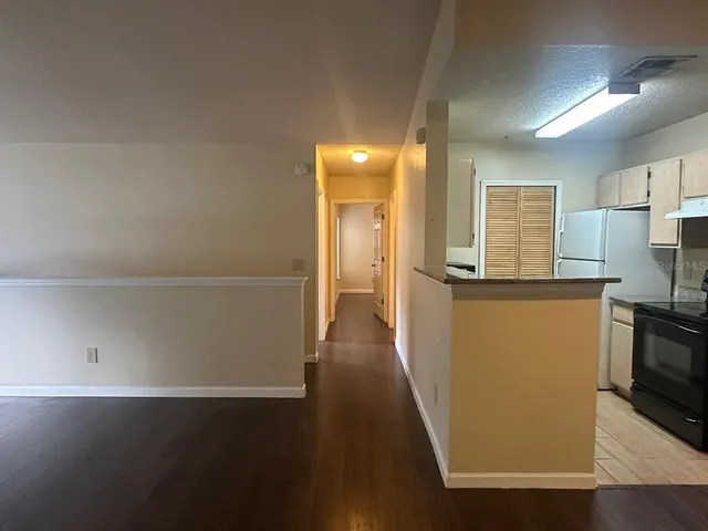 a view of a kitchen with a refrigerator a stove top oven and cabinets