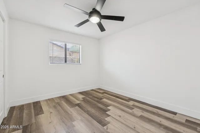 an empty room with a window and a ceiling fan