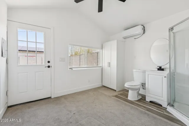 a bathroom with a toilet sink a mirror and vanity