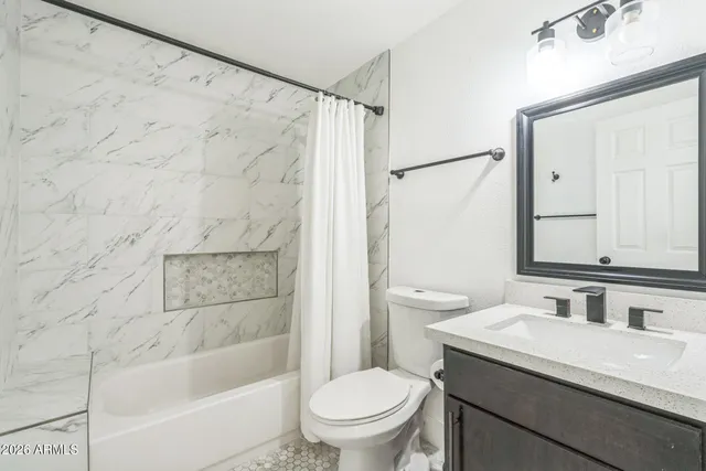 a bathroom with a granite countertop sink a toilet and shower