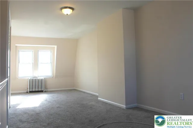 an empty room with windows and cabinet