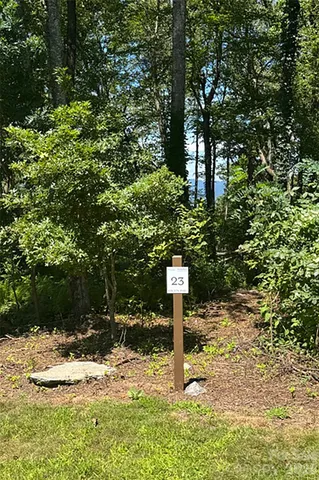 a sign board with tall trees