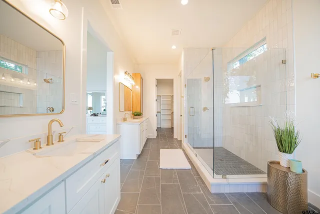 a bathroom with a double vanity sink and shower