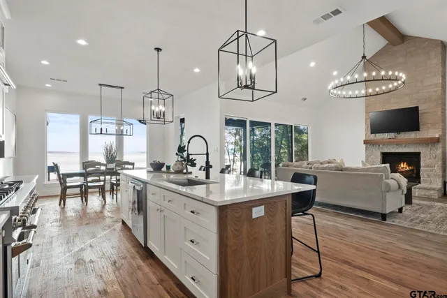 a kitchen with stainless steel appliances a table chairs stove and wooden floor