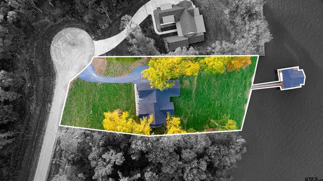 a aerial view of a house with a yard and deck