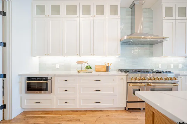 a kitchen with stainless steel appliances granite countertop a stove a sink and a microwave