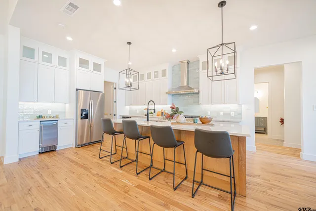 a view of a dining room and livingroom with furniture wooden floor a rug a chandelier