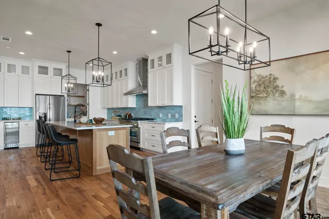 a view of a dining room and livingroom with furniture wooden floor a chandelier