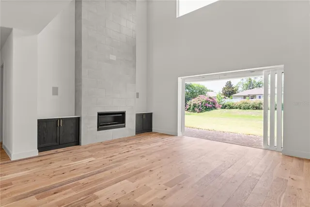 a view of empty room with wooden floor and fireplace
