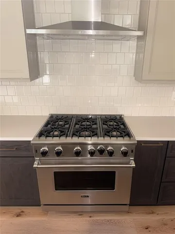 a stove top oven sitting inside of a kitchen