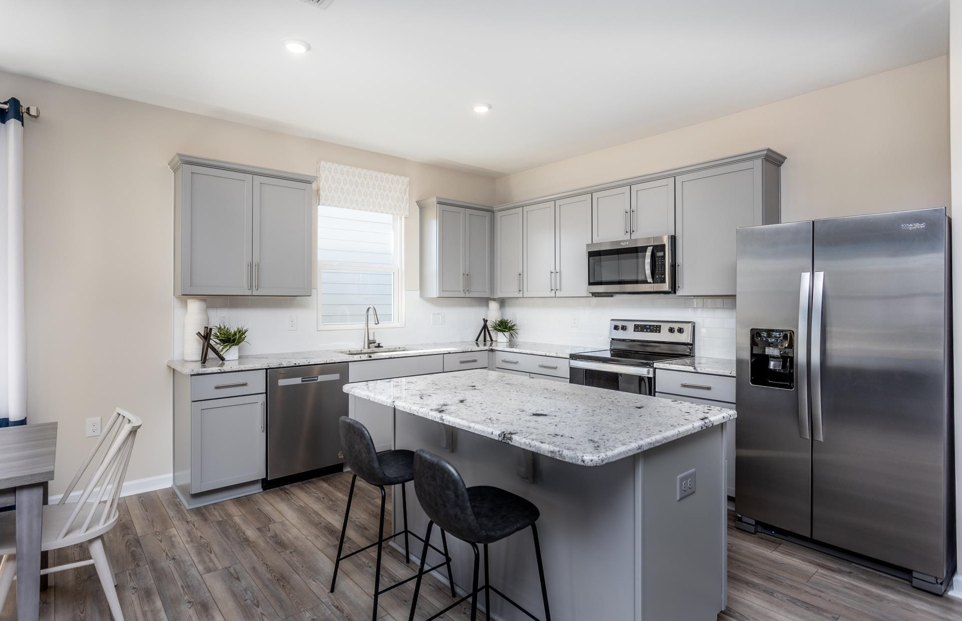 3508 New Town Road Raleigh, NC 27604 - Photo 9 of 27 a kitchen with a refrigerator a stove a sink and chairs