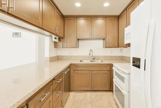 a kitchen with a sink a refrigerator a microwave and cabinets