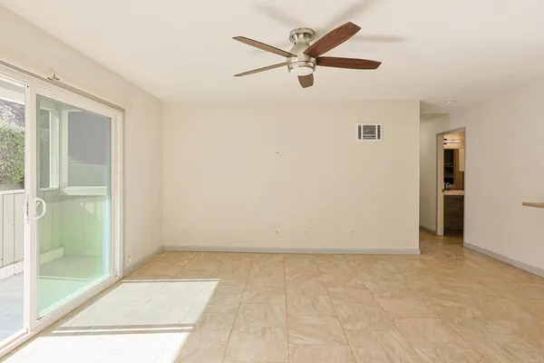 an empty room with fan and windows
