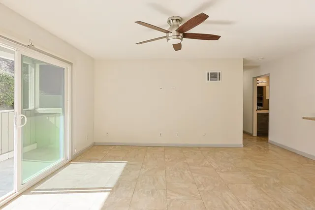 an empty room with fan and windows