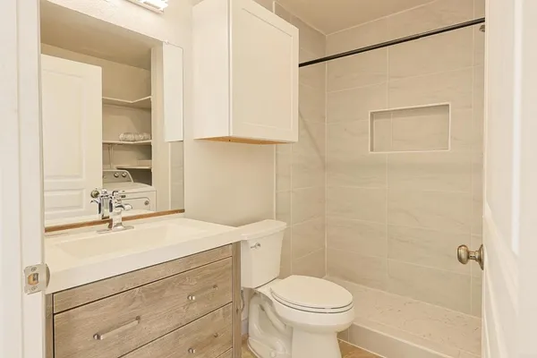 a bathroom with a sink a toilet and shower