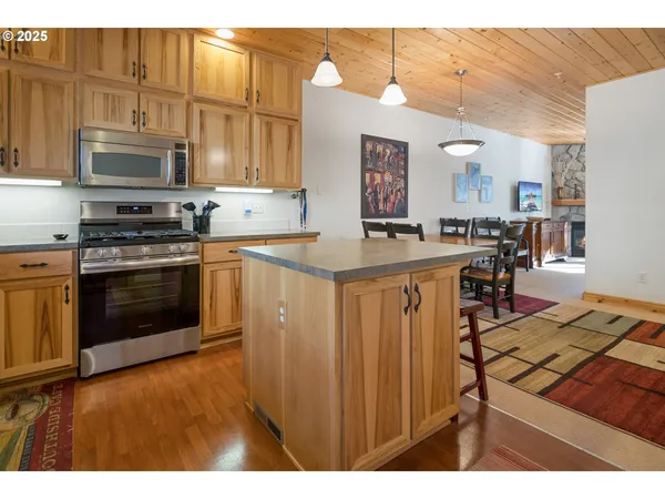a kitchen with stainless steel appliances granite countertop a stove a sink dishwasher and a microwave oven with cabinets