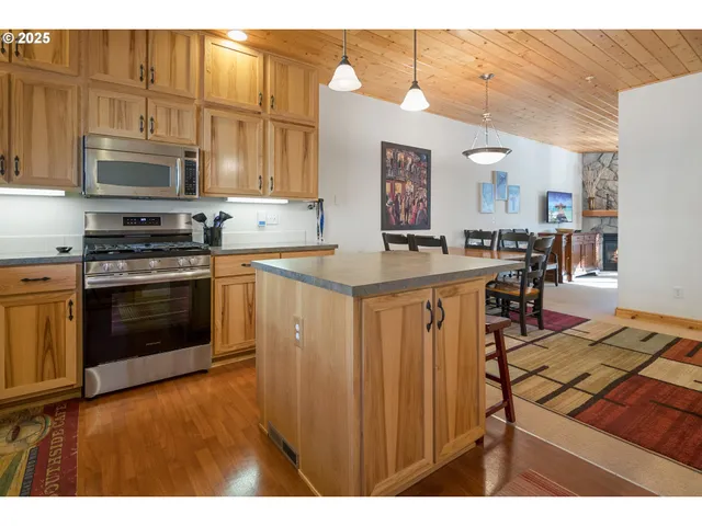 a kitchen with stainless steel appliances granite countertop a stove a sink dishwasher and a microwave oven with cabinets