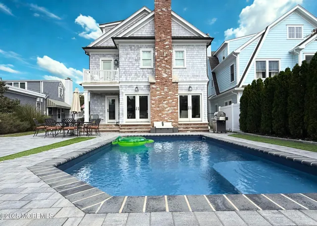 a view of a house with pool and sitting area